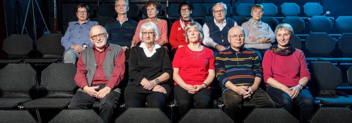 Gruppenfoto in Stuhlreihen sitzend